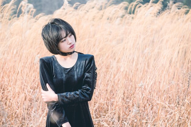 portrait of style woman standing amidst reed field