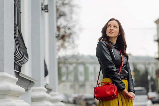 Portrait of a stylish brunette business woman with a red handbag