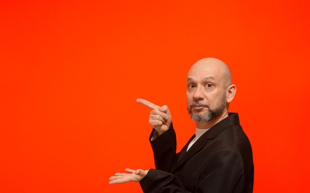 Portrait of a stylish business man making hand gestures looking at the camera isolated on orange background person