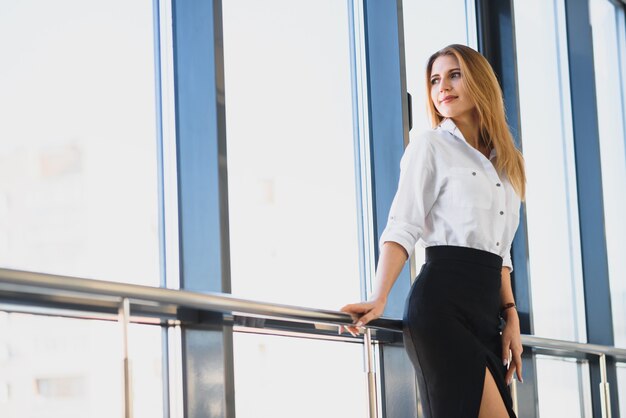 Portrait of stylish businesswoman near window in office