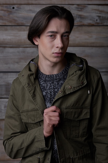 Portrait stylish casual man posing on wood wall