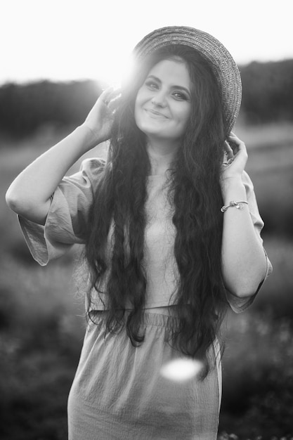 Portrait of stylish gorgeous female walking at the field posing looking at the camera