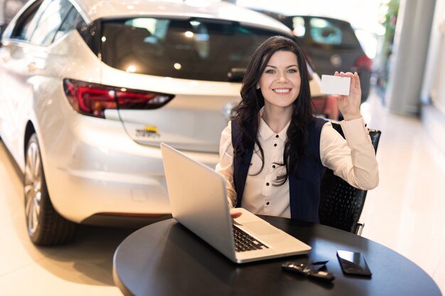 Portrait of stylish insurance agent holding a card