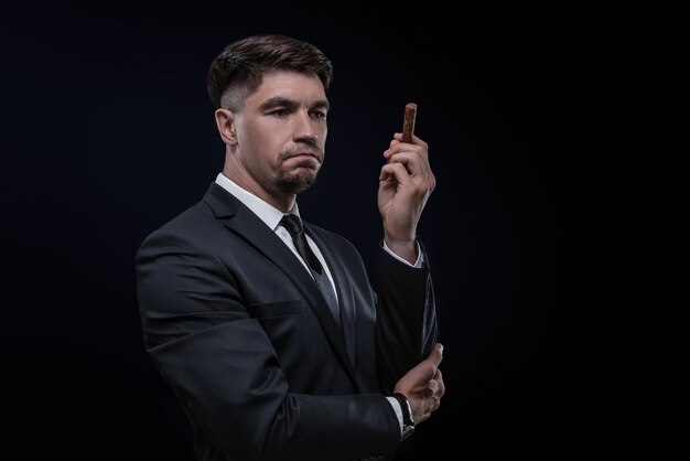 Portrait of a stylish man in a suit with a cigar. Business concept. Mixed media