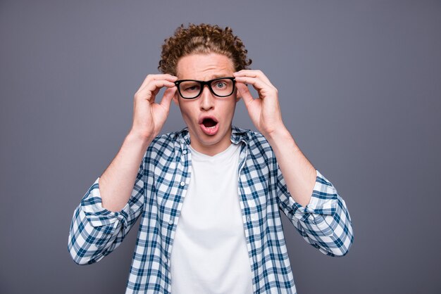 Portrait of stylish man with wavy hair in casual checkered shirt