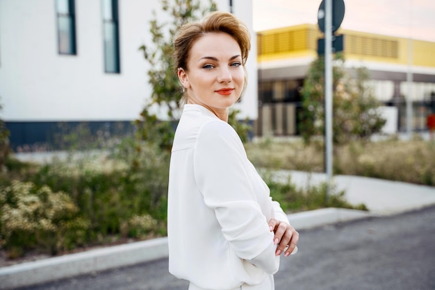 Portrait of stylish middle aged businesswoman with arms crossed looking at camera on the street