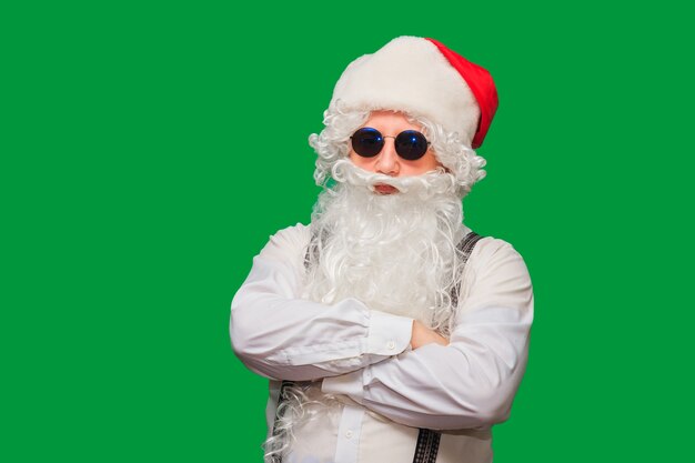 Portrait of stylish Santa Claus on color wall.