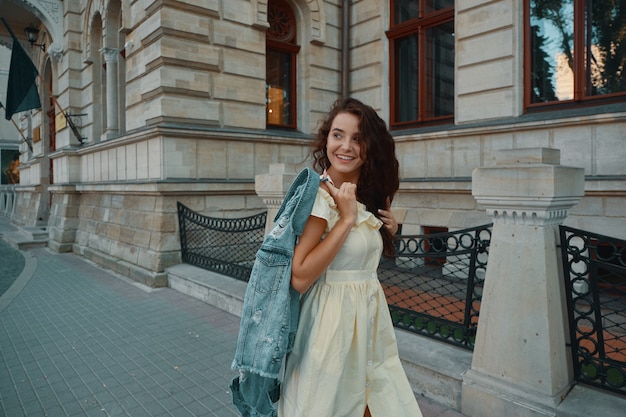 Portrait of stylish smiling, happy brunette woman walking on the street