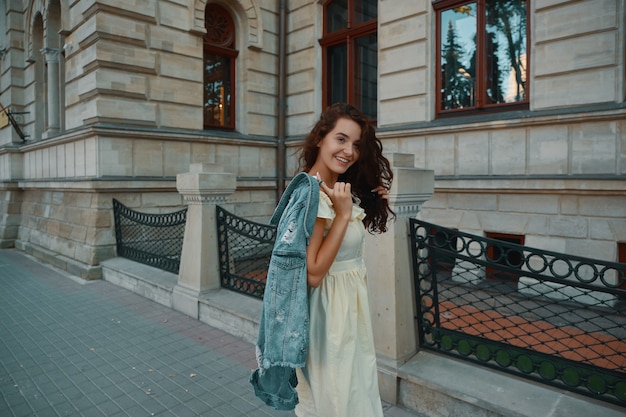 Portrait of stylish smiling, happy brunette woman walking on the street