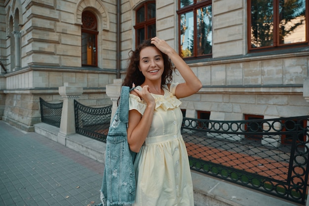 Portrait of stylish smiling, happy brunette woman walking on the street