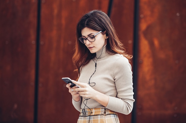 Portrait of stylish woman holding mobile phone