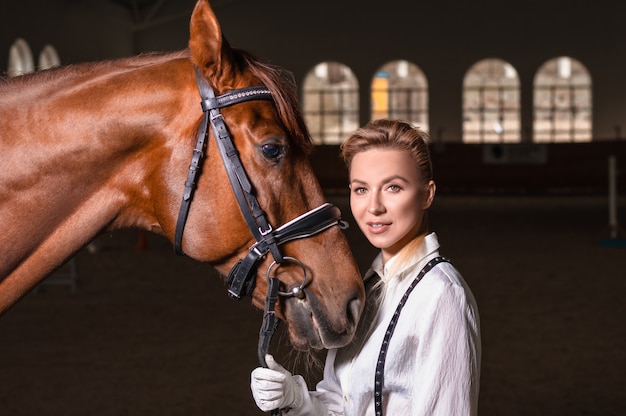 Portrait of a stylish woman hugging a thoroughbred horse. Love and care concept. Mixed media