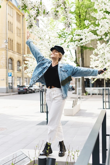 Portrait of stylish woman wearing jeans jacket and black cap