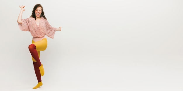 Portrait of stylish young girl cheerfully posing isolated over grey studio background Extraordinary fashion