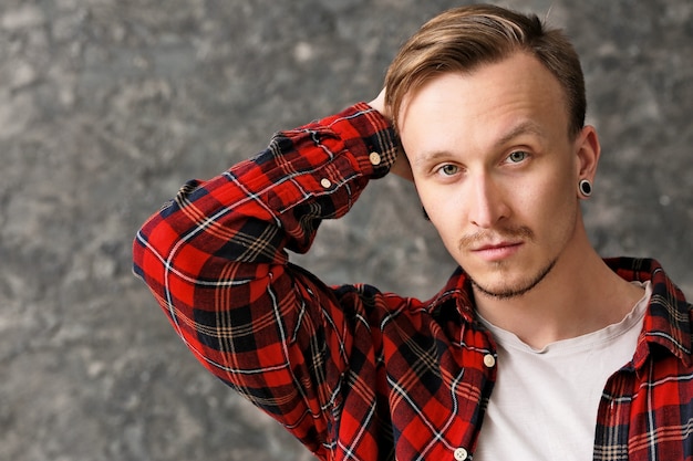 Portrait of stylish young man on grunge surface