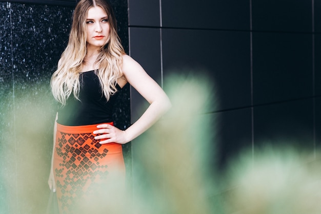 Portrait of stylish young woman walking in modern city 