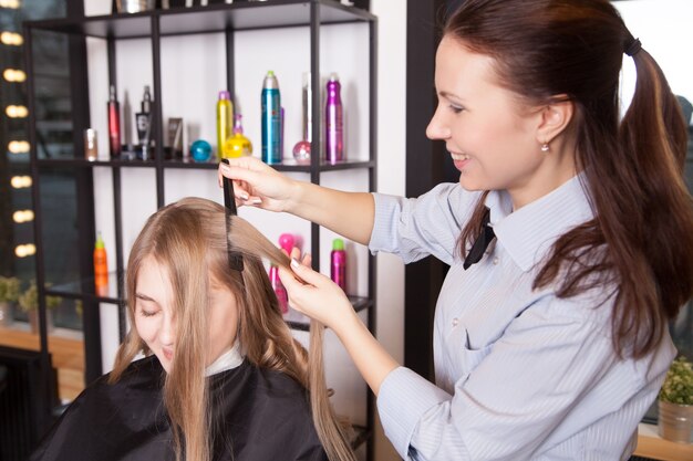 Portrait of stylist making curls hair in salon