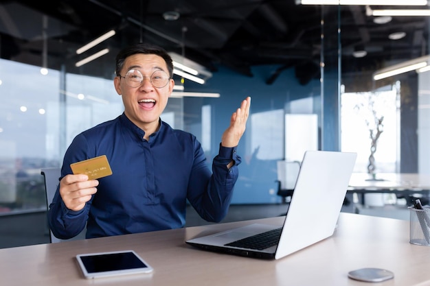 Portrait of a successful asian man inside the office a mature businessman looking joyfully at the