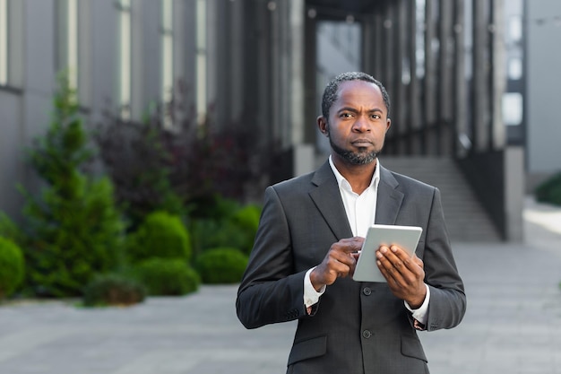 Portrait of a successful black senior businessman investor lawyer standing near an office center