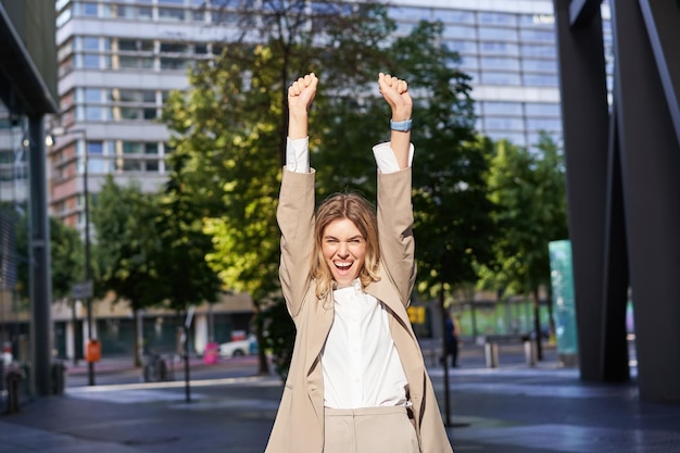 Portrait of successful business woman young corporate woman celebrating victory achievement triumphi