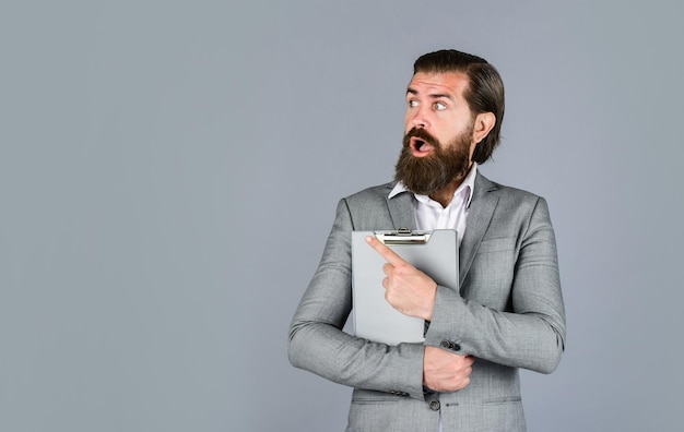 Portrait of successful businessman dressed in formal clothes serious boss with document Ready for sale Pleasant cheerful handsome realtor holding folder bearded man working in office copy space