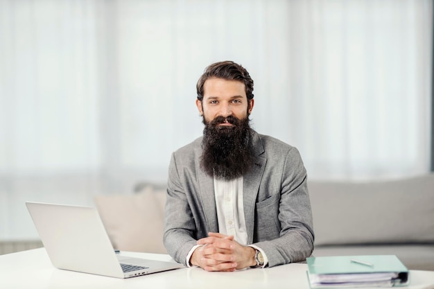 Portrait of a successful businessman sitting at his cozy home and smiling