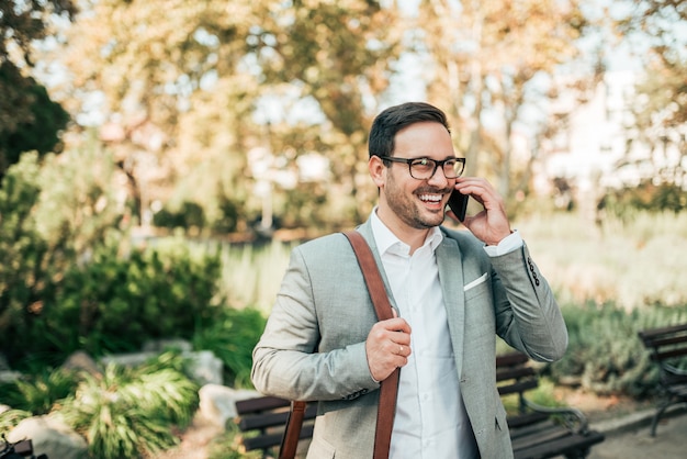 Portrait of a successful businessman talking on smart phone outdoors.