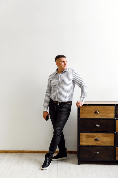 Portrait of a successful businessman. young businessman in a shirt and jeans on the background of a light office. humble company director in a white office