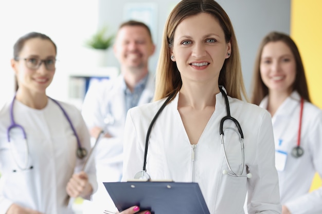 Portrait of successful female doctor on background of colleagues