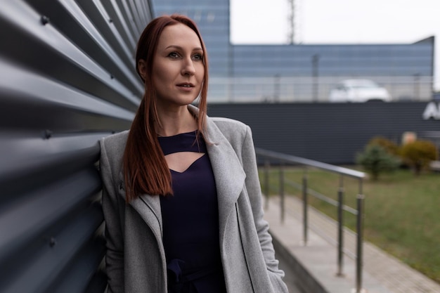 Portrait of a successful fortyyearold redhaired businesswoman against the backdrop of the office