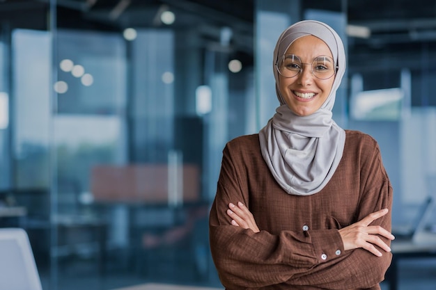 Portrait of successful and happy businesswoman in hijab office worker smiling and looking at camera