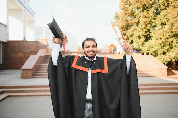 Portrait of successful indian student in graduation gown