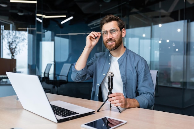 Portrait of successful man inside office businessman with professional microphone recording online