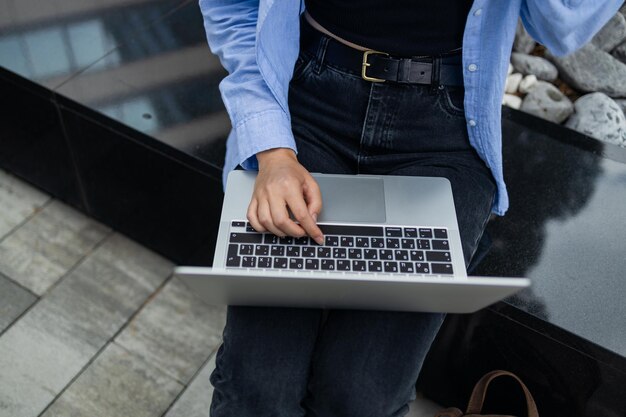 Photo portrait of successful professional businesswoman in smart casual using digital laptop outdoors in