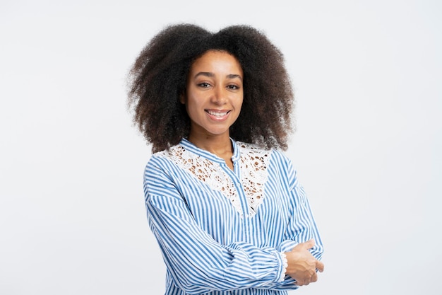 Foto ritratto di donna d'affari afroamericana sorridente di successo con i capelli ricci con le braccia incrociate guardando la fotocamera isolata su sfondo bianco concetto di shopping pubblicitario