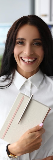 Foto ritratto di successo donna d'affari sorridente tenendo il blocco note