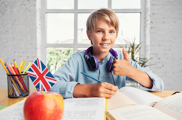 Photo portrait of successful teenage schoolboy sitting in the classrooom