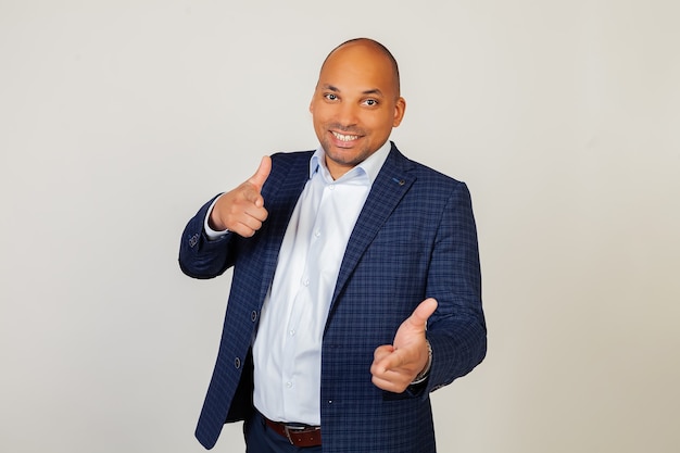 Photo portrait of a successful young african american businessman guy pointing his fingers with a happy and funny face. good energy and vibes.
