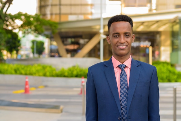 Portrait of successful young African businessman wearing suit and tie while smiling