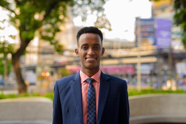 Portrait of successful young African businessman wearing suit and tie while smiling