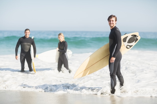 Portrait of surfer friends with surfboard standing on the beach