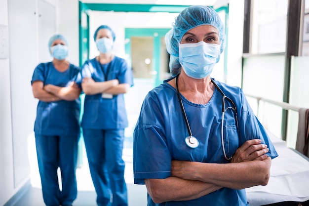 Portrait of surgeon and nurses standing with arms crossed