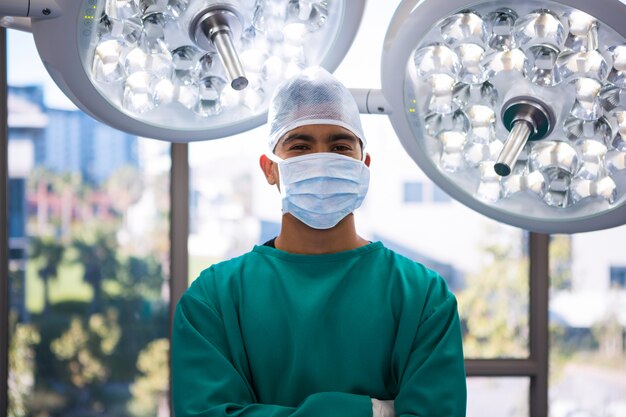 Portrait of surgeon standing with arms crossed in operation room