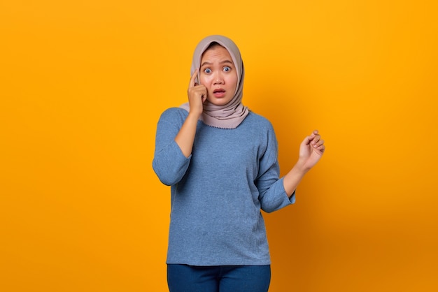 Portrait of surprised Asian woman realizing new a thought with open mouth over yellow background