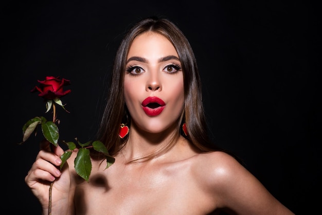 Portrait of surprised attractive woman with red rose