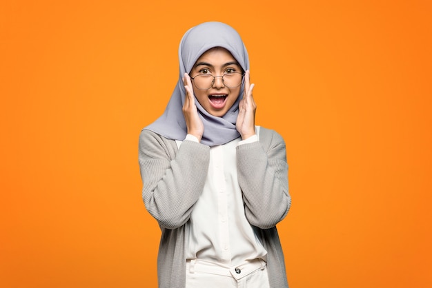 Portrait of surprised beautiful Asian woman while holding eyeglasses