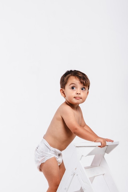 Foto ritratto di un bambino sorpreso che guarda in alto su uno sfondo bianco