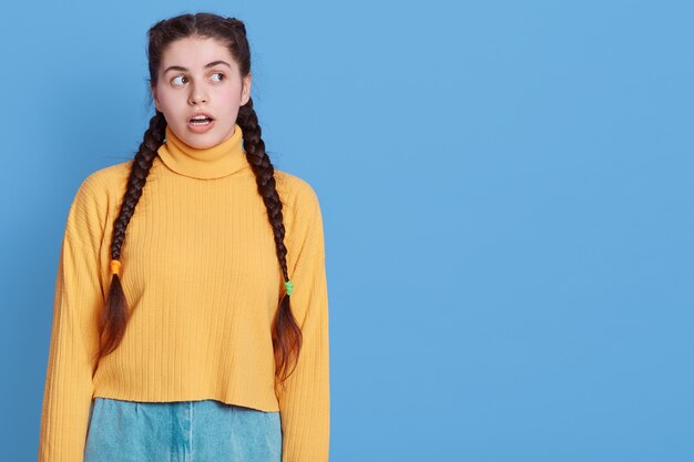 Portrait of surprised excited girl with dark hair and pigtails