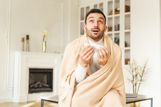 Portrait of a surprised ill young Caucasian male with a plaid round his shoulders staring upwards