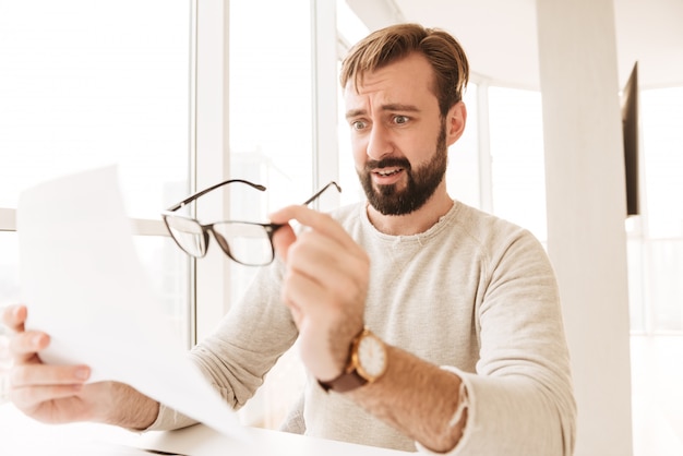 Portrait of a surprised man working with documents